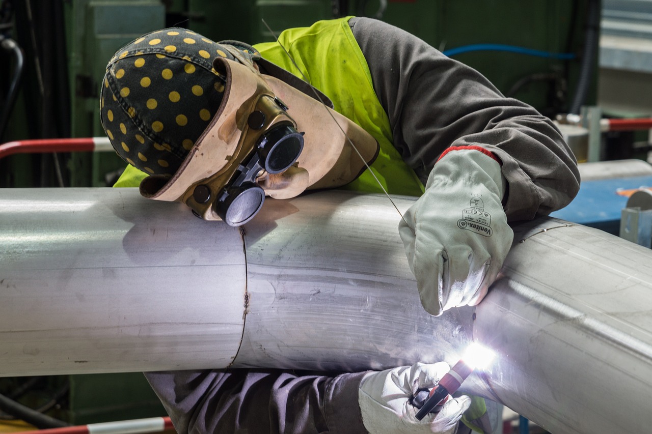welder uses leather work welding gloves while working on pipe